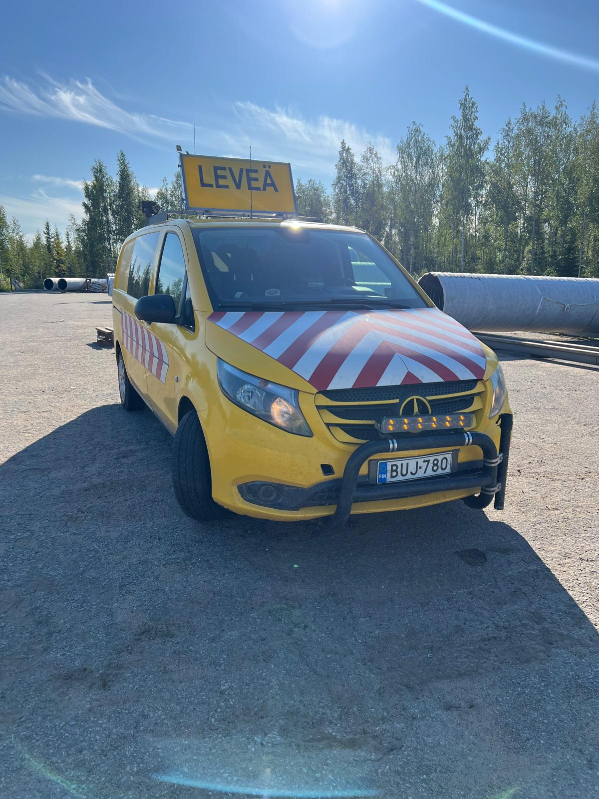 Keltainen etuauto LEVEÄ-kilvellä.